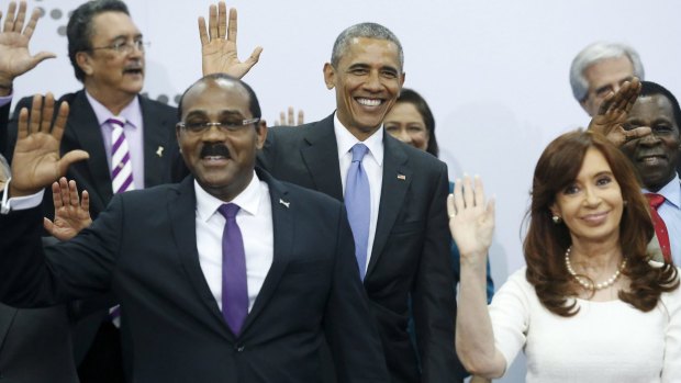 US President Barack Obama, flanked by Antigua and Barbuda's Prime Minister Gaston Browne and Argentinian President Cristina Fernandez de Kirchner, waves during a group photo in Panama City.
