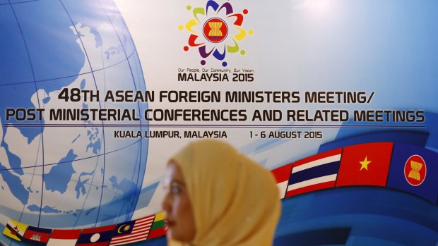 A woman waits to greet delegates of the 48th ASEAN foreign ministers meeting in Kuala Lumpur, Malaysia.