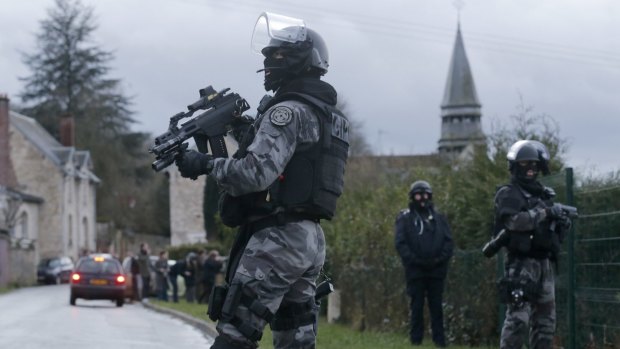 Hunting for terror suspects: Member of the French GIPN intervention police force secure a neighbourhood in Corcy, north-east of Paris. It sits next to the town of Longpont, which has been surrounded by police, according to reports.