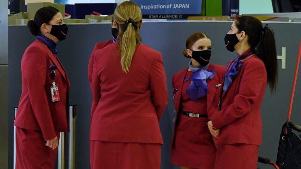 Virgin Australia staff wearing masks at Sydney Airport in December. Virgin crew are still required to wear masks on board flights.