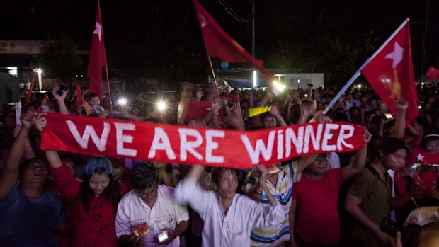 Hopeful supporters of Aung San Suu Kyi's National League for Democracy party anticipate the result of general election outside the party's headquarters on Sunday.