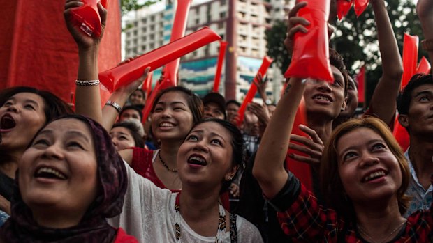 Crowds cheer as they watch votes being counted at a National League for Democracy rally event at the end of voting day in Yangon. 