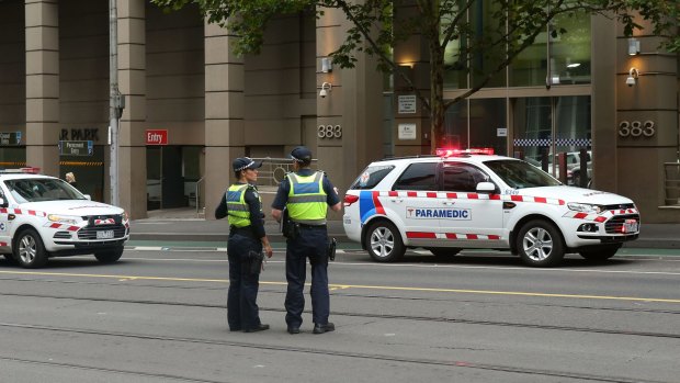 Police outside the AFP building on La Trobe Street on Monday evening.