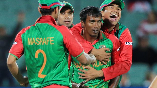Match winner: Rubel Hossain is embraced by teammates after dismissing Eoin Morgan   in Adelaide.