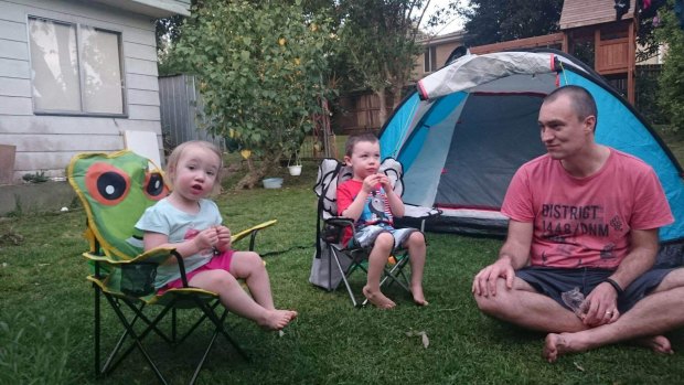 Eliza, 2, Lincoln, 4 and dad Martin Swinburn in the backyard of their Asquith home, which will likely be demolished and rebuilt, due to loose-fill asbestos found in the roof of the home. 