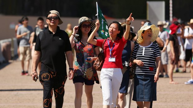 A tour guide leads a group of tourists towards the Sydney Opera House in Sydney: Australia needs to lift its game if it wants to attract more visitors.