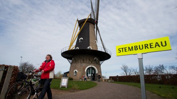 A woman leaves after casting her vote at the Kerkhovense Molen, a windmill turned polling station in Oisterwijk, south central Netherlands.