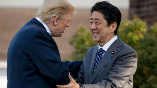 President Donald Trump greets Japanese Prime Minister Shinzo Abe at Kasumigaseki Country Club in his first trip to Asia. 