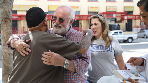 'They discover they are the hero of their own story': Greg Boyle gets a hug from a staffer in Los Angeles.