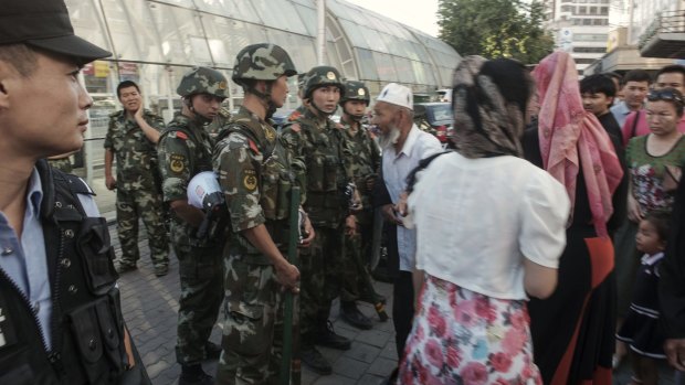 Police stand guard in a Uighur neighbourhood in Xinjiang in July.