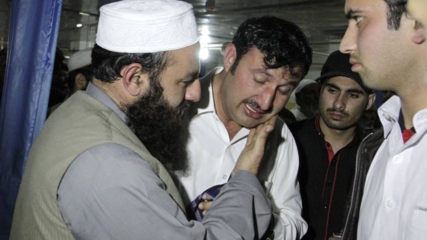 A relative is comforted while mourning the death of Samiullah Afridi.