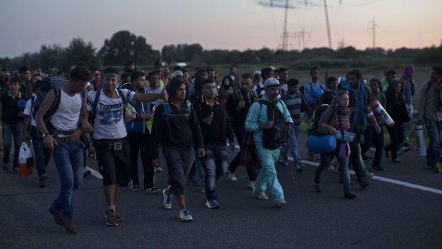 A group of migrants and refugees walks along a highway leading to Budapest, after breaking through Hungarian police lines near the Serbian border.
