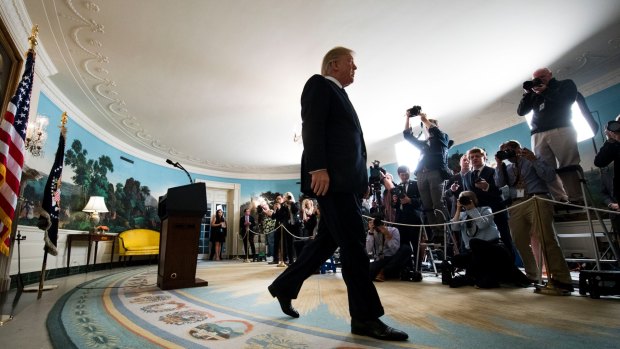 Donald Trump exits after announcing that he will not certify Iran's compliance with the nuclear deal that was negotiated by his predecessor.