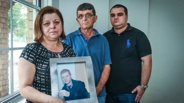 David and Sylvia Veljanovski with their son Jim Veljanovski and a portrait of missing Nick at their Yagoona home.