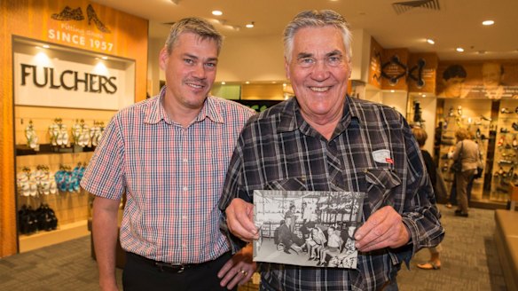 Troy (left) and Trevor (right) at Fulchers Shoes, holding a picture of Trevor's father, Gordon, at work.