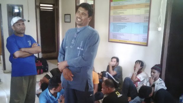 Mochamad Jahangir Husain, centre, at the Cidaun police station in West Java with the other passengers from the boat (seated).