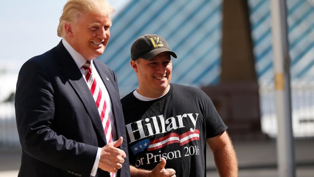 Mike Schuetz, a US Marine veteran and owner of Hawkins Guns, in Hawkins, Wisconsin, poses for photos with Republican Presidential candidate Donald Trump, left, at the Milwaukee County War Memorial Centre in Milwaukee, Wisconsin.