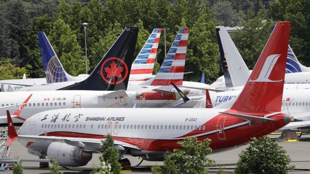 Dozens of grounded Boeing 737 MAX airplanes crowd a parking area adjacent to Boeing Field in Seattle. 