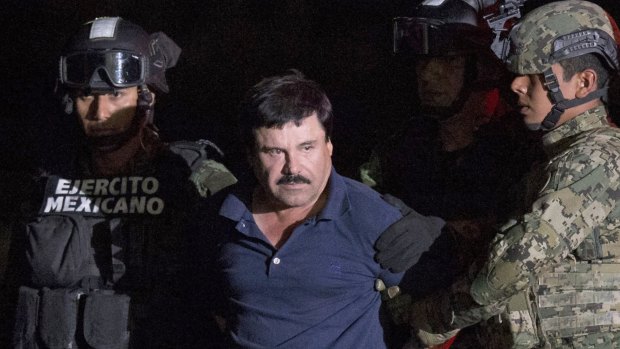 Mexican drug lord Joaquin "El Chapo" Guzman is escorted by army soldiers  to a waiting helicopter in January.