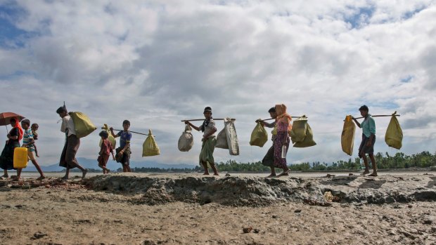 Rohingya Muslims, who crossed over from Myanmar into Bangladesh, walk towards a refugee camp in Shah Porir Dwip, Bangladesh.