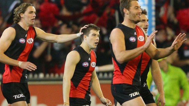Joe Daniher (left) celebrates a goal with Zac Merrett and teammates. The Bombers got off to a flying start. 