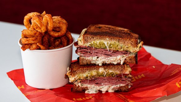 The menu is focused on sandwiches (Reuben pictured), curly fries, shakes and coffee.