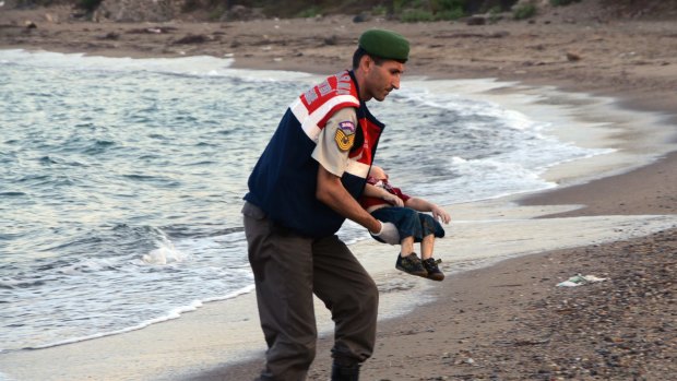 A Turkish paramilitary police officer carries the body of Aylan Kurdi in September.