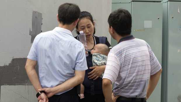 Yuan Shanshan, wife of detained Chinese lawyer Xie Yanyi, is questioned by security staff near the Tianjin court.
