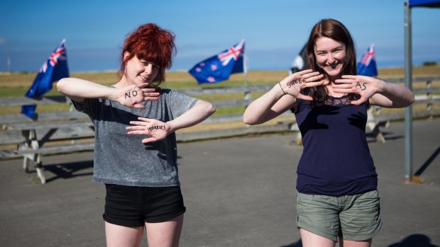 Girls write traditional Kiwi greetings on their hands in New Zealand.