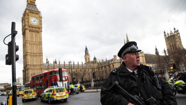 An armed police officer stands guard near Westminster Bridge.