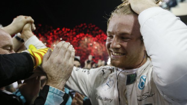 Mercedes driver Nico Rosberg celebrates with team members at the Yas Marina track in Abu Dhabi.