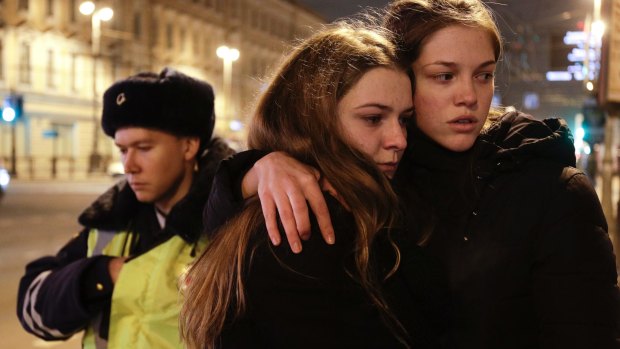 Women grieve near the subway station in St Petersburg after a blast tore through a subway train deep under Russia's second-largest city on Monday.