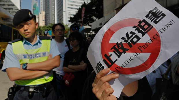 A police officer watches protests in Hong Kong on Sunday.