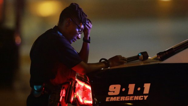 A Dallas police officer guards an intersection after the shooting. 