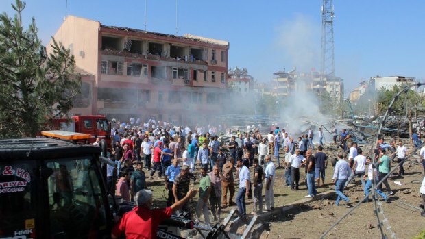 Turkish authorities and residents stand outside the damaged building after the explosion.