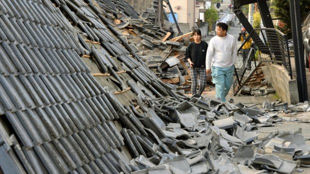 Residents walk along collapsed houses in Mashiki, Kumamoto prefecture, southern Japan.