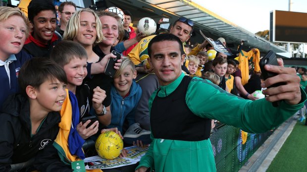 Tim Cahill takes a selfie with fans in Perth on Monday.