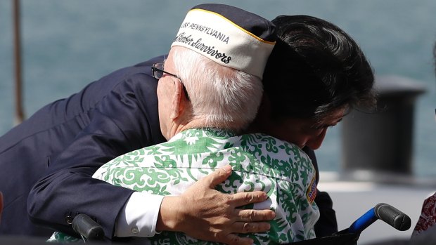 Shinzo Abe embraces World War II Pearl Harbour survivor  Sterling Cale on Kilo Pier, overlooking the USS Arizona Memorial on Tuesday.
