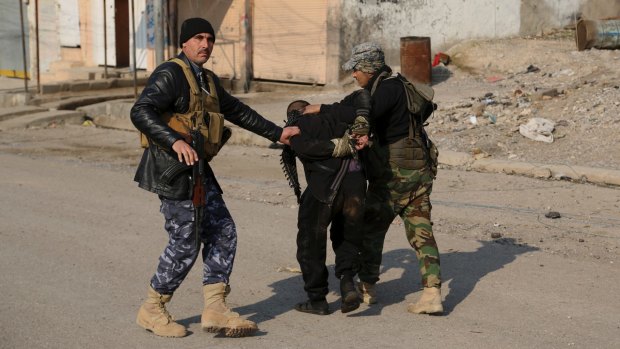 Iraqi security forces arrest a suspected fighter with the Islamic State group during a military operation to regain control of the eastern side of Mosul, Iraq.