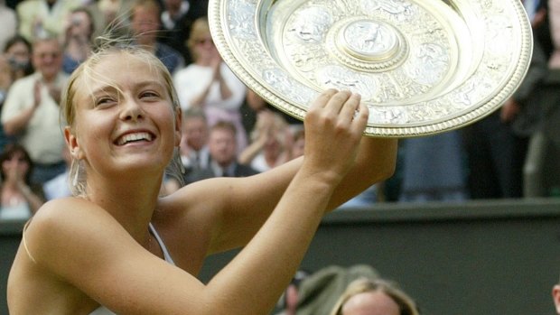 Maria Sharapova holds the winner's trophy after defeating Serena Williams in 2004 Wimbledon final.