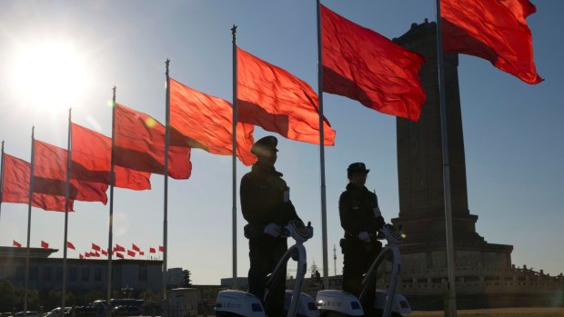 Chinese police officers patrol on motorised platforms on Tiananmen Square