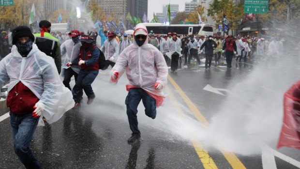 South Korean riot police use a pepper water cannon to stop protesters marching towards the presidential office in Seoul.