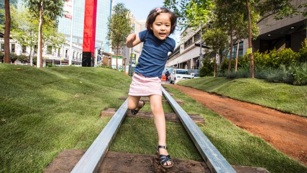 At the Future Street Project at Circular Quay, four-year-old Madeleine Boxsell jumps light rail tracks surrounded by grass. 
