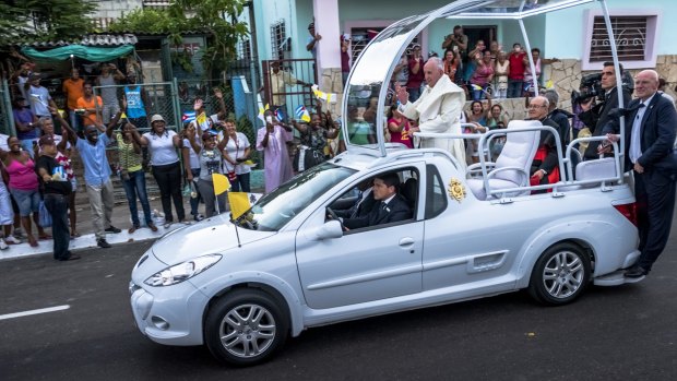 Cubans line Havana streets as Pope Francis waves from his motorcade.