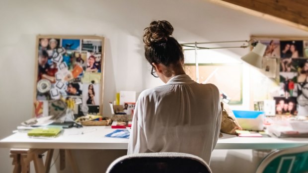 Young businesswoman at her desk in home studio.