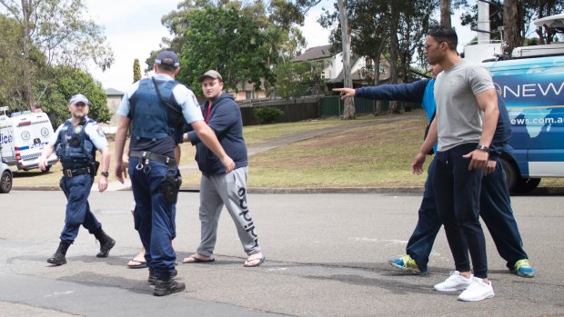 Relatives clash with police and media at the scene of Tuesday's fatal shooting in Georges Hall.