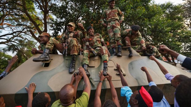 Zimbabweans reach out to touch and thank soldiers, for the army's role in Mugabe's demise.