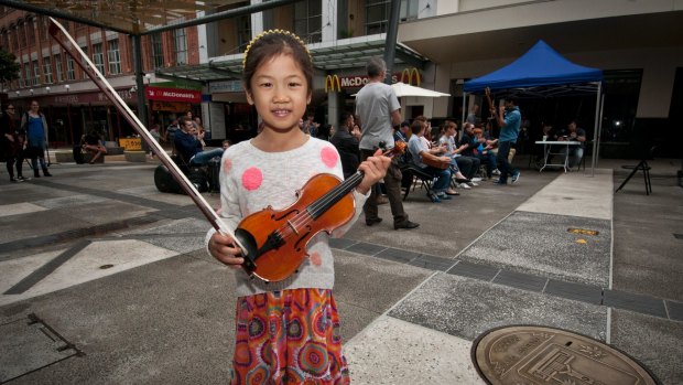 Sydelle Zhang, 7, wants to receive a busking permit so she can play her violin in Queen Street Mall.
