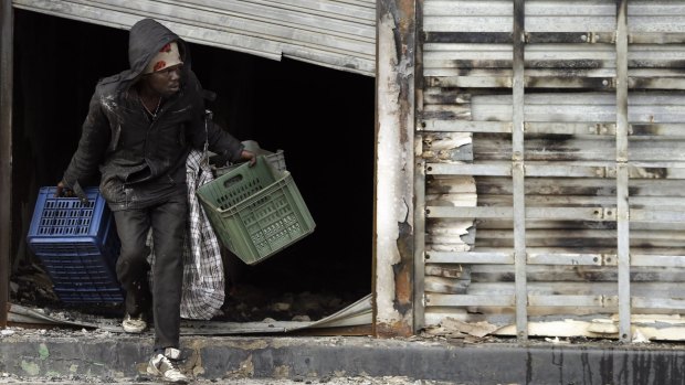 A man leaves a burnt shop owned by a foreign national in Johannesburg.