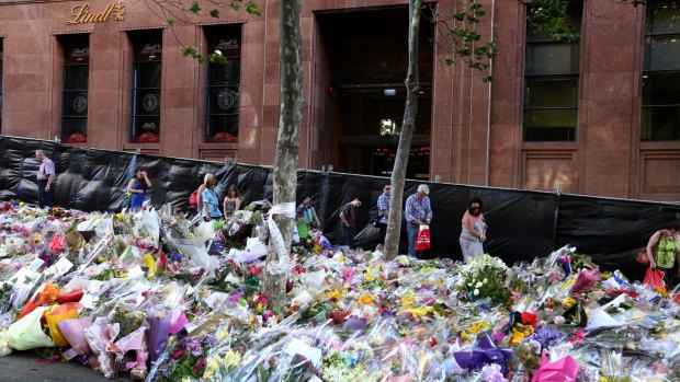 Flowers laid in tribute outside the Lindt Cafe following the fatal siege: The cafe will reopen in March.
